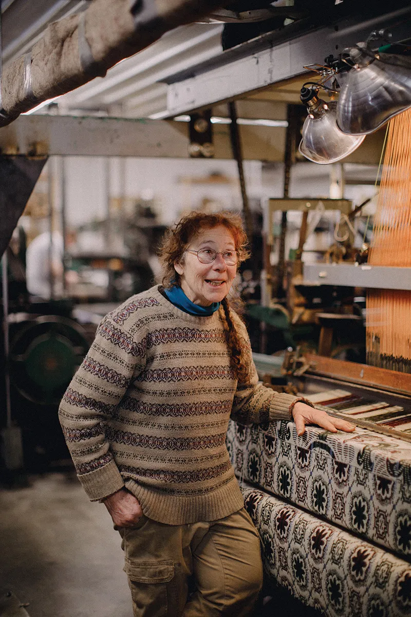 a women stands for a portrait in her textile workshops