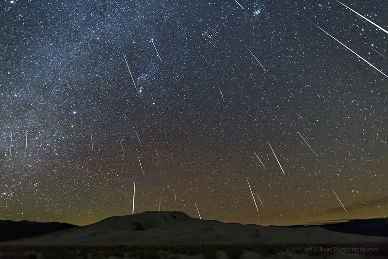 a meteor shower over mountains