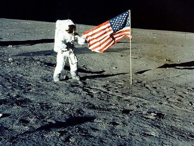 Charles "Pete" Conrad Jr. stands with the U.S. flag on the lunar surface during the Apollo 12 mission.