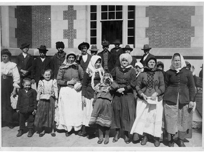 Immigrants outside a building on Ellis Island, circa 1900. 
