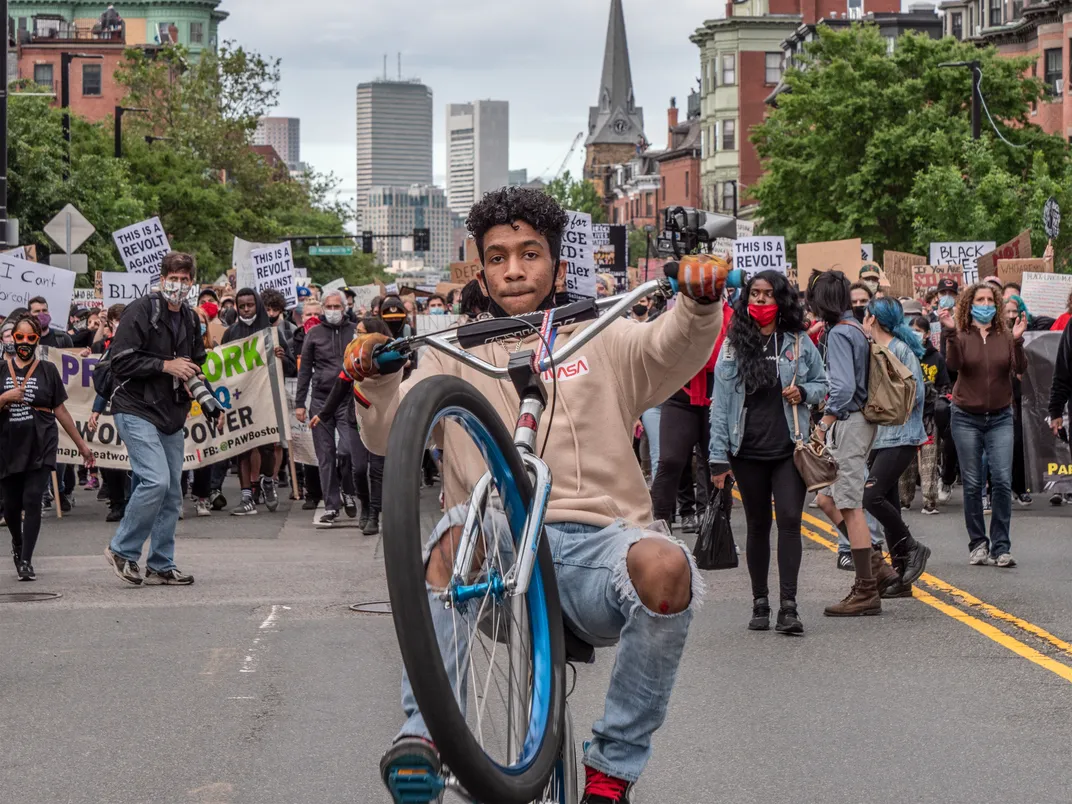 young people wearing masks participate in a protest march