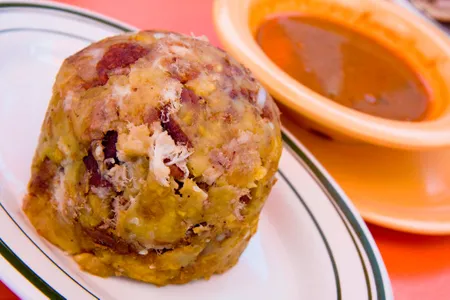 Puerto Rico&#39;s unofficial national dish usually consists of fried green plantains mashed with garlic,&nbsp;chicharr&oacute;n&nbsp;(deep-fried pork skin) and cilantro.