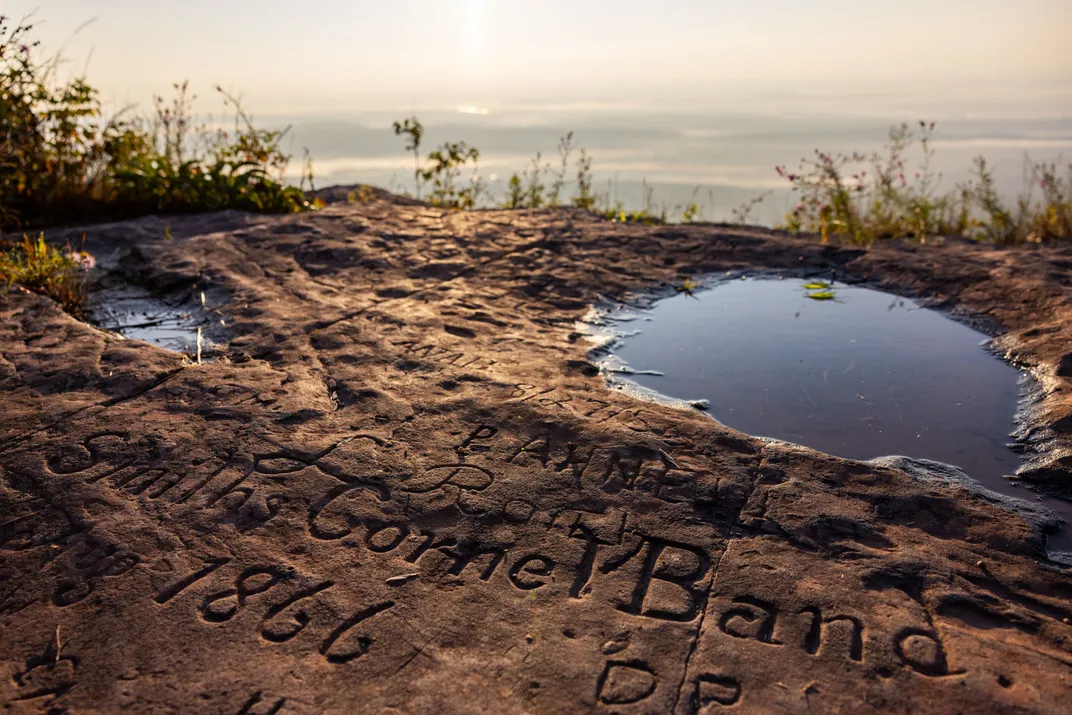 engraved graffiti onto a cliffside rock ledge
