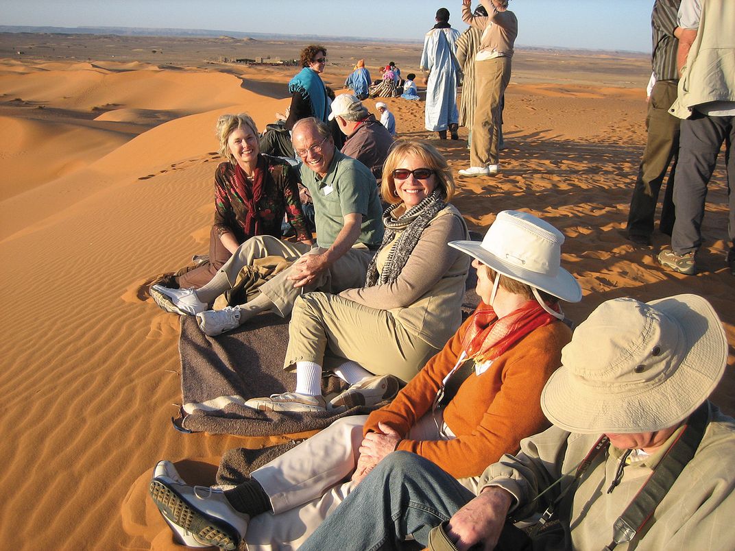 Smithsonian travelers relax on the sand dunes. Credit: Amy Kotkin