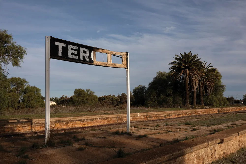A tattered sign on an abandoned railway stop