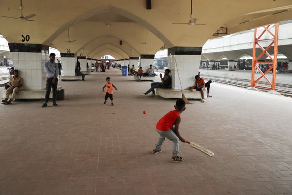 Two boys playing cricket at railway station thumbnail