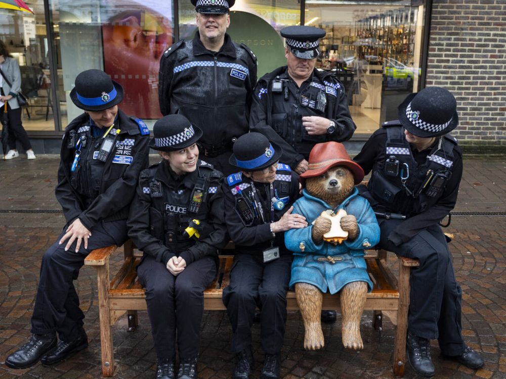 Police officers posing around statue of bear