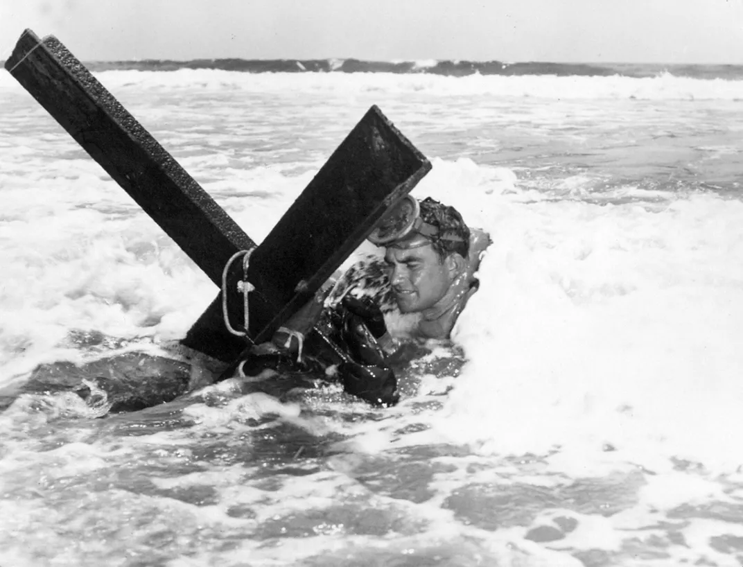 A UDT man rigging an enemy obstacle replica