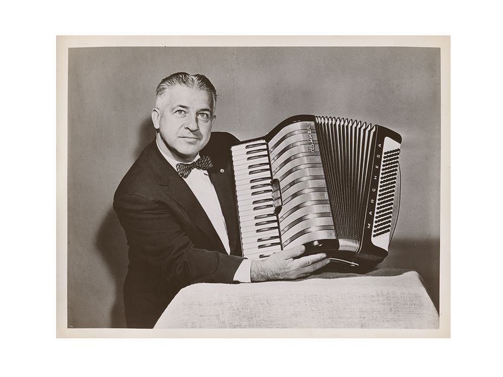 Photograph of John Vassos holding the Marchesa model accordion he designed for M. Hohner, 195-? / unidentified photographer. John Vassos papers, 1915-1989. Archives of American Art, Smithsonian Institution.