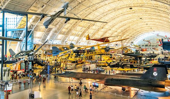The Boeing Aviation Hangar at the Steven F. Udvar-Hazy Center is a vast open space filled with airplanes on both the floor and hanging from the ceiling, tilted at angles that convey the impression of flight.