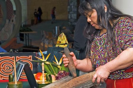 Juanita Velasco (Ixil Maya) grinds cacao beans into chocolate during the 2011 Power of Chocolate Festival. The Maya and Aztec peoples valued cacao pods as symbols of life, fertility and even currency. 