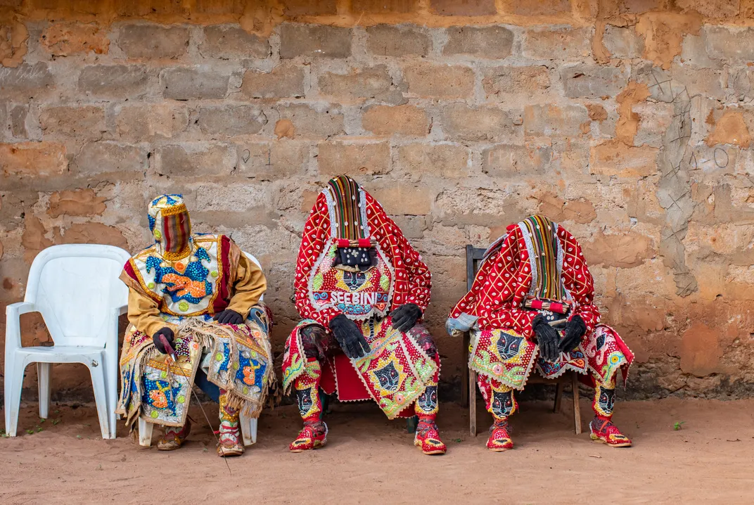 Masquerade dancers rest during the Egungun ceremony