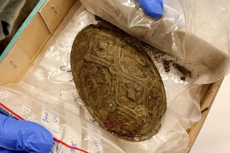 Researchers found bird bones and jewelry, including this bowl-shaped brooch, in the grave.