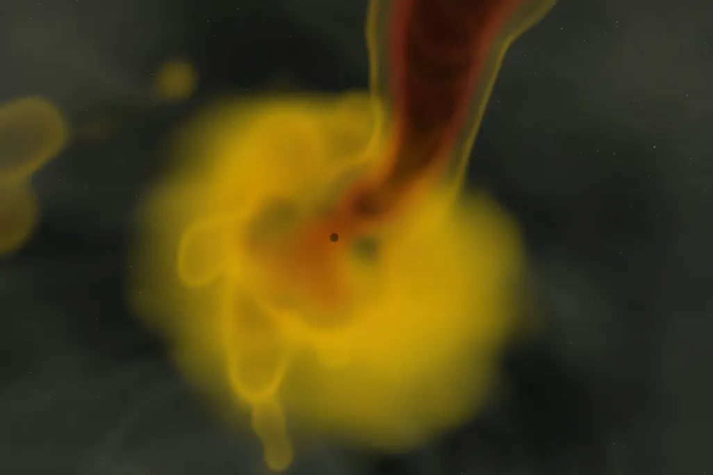 A tiny dark dot surrounded by an orange-yellow cloud