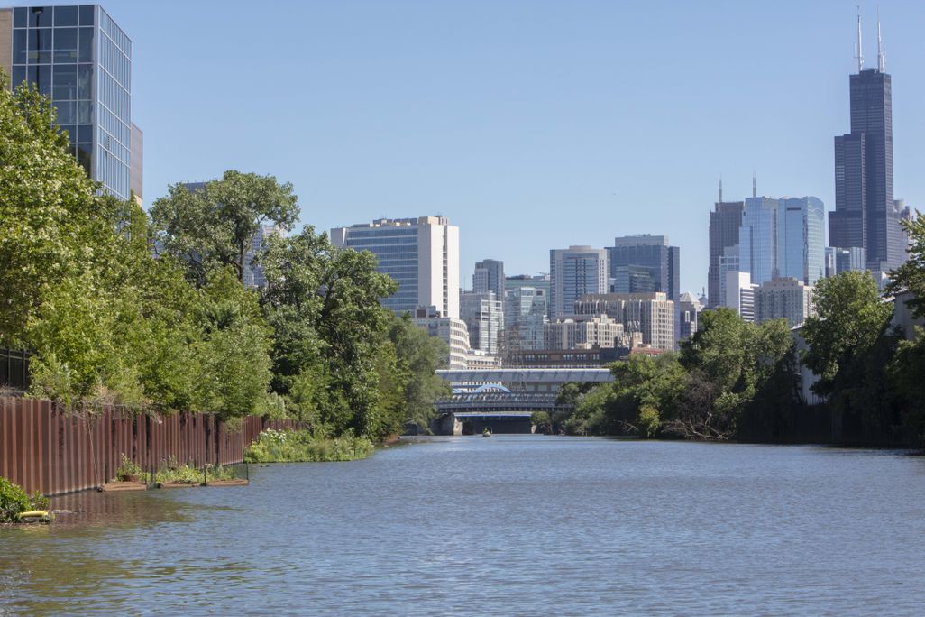 Waterway flowing in front of tall skyscraper buildings