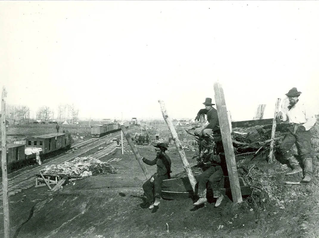 Men sit near the Manassas Junction railroad in 1862