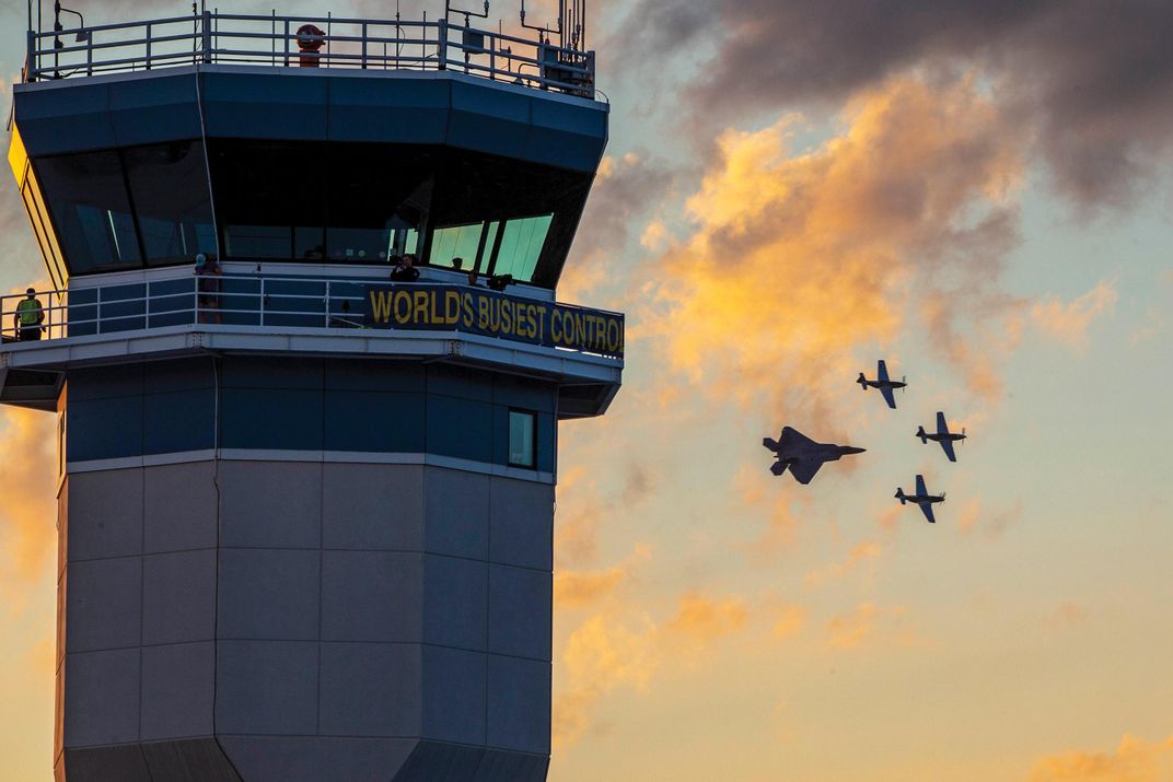 Raptor and Mustangs by a control tower