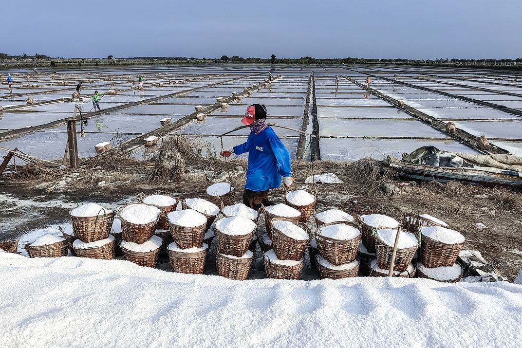 A man harvesting salt on a salt farm. | Smithsonian Photo Contest ...