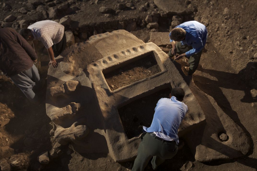 None 'men working on a stone structure'