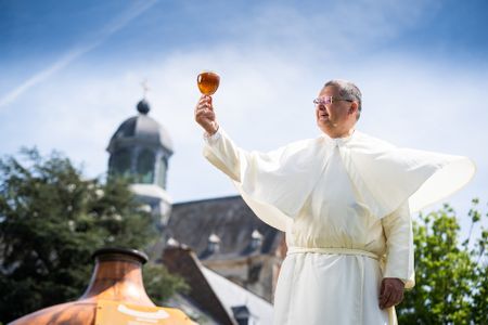 Father Karel Stautemas raising a glass of Grimbergen beer