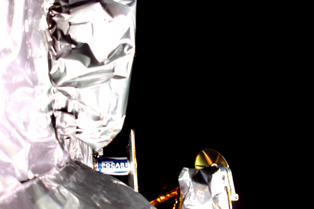 A photo from a camera on one of Peregrine&#39;s payload decks shows some of the spacecraft&#39;s payloads, as well as a sliver of Earth in the upper right.