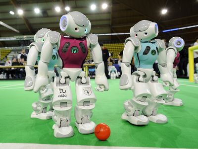 Nao robots race—slowly—to the open ball. 