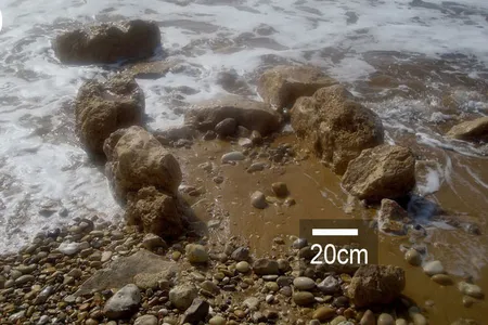 Exposed stone-built features in shallow water at the archaeological site of Tel Hreiz.