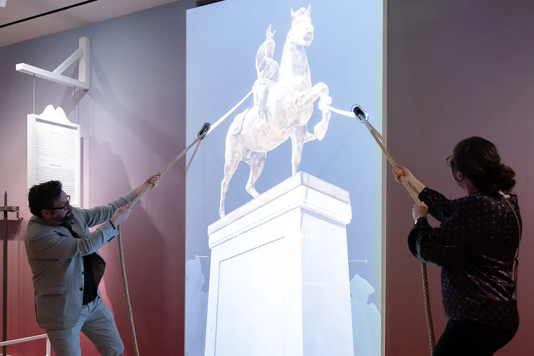 Visitors pull ropes to recreate the statue's destruction