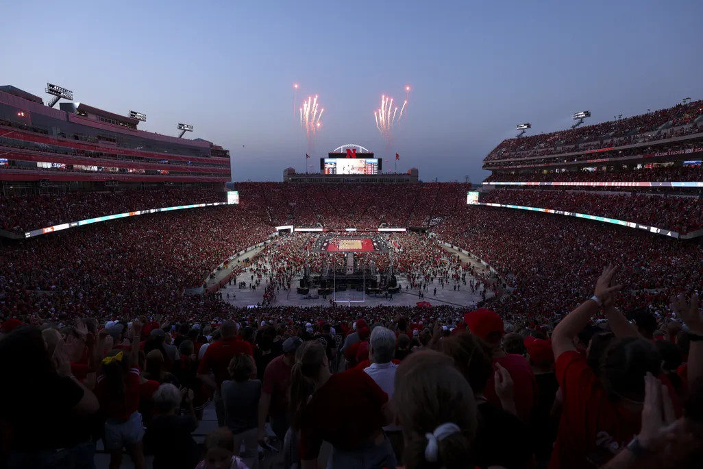Dusk at a football stadium with fireworks in background