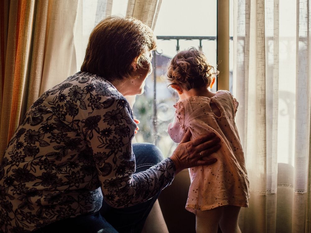 Grandmother and child looking out window