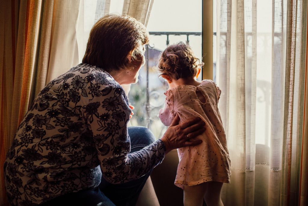 Grandmother and child looking out window