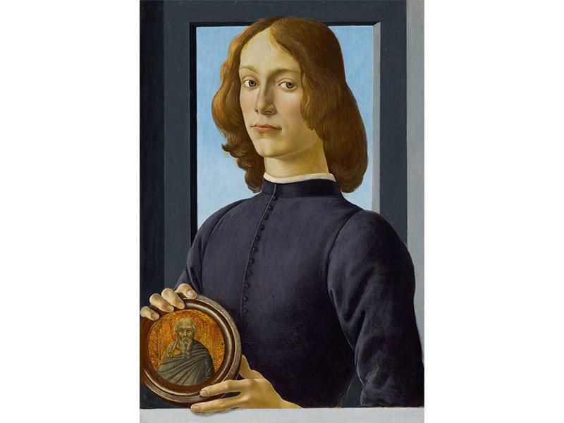 A young man faces the viewer, with gray-green eyes, pale skin and gold-brown hair, wearing a dark purple tunic, in front of a simple gray window with a plain blue sky; holds a circular medallion with his two hands depicting an elderly saint