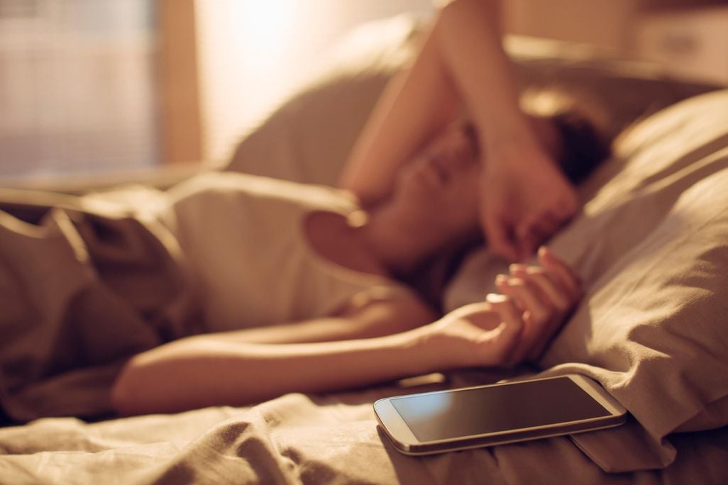 Woman in Bed Next to Smart Phone
