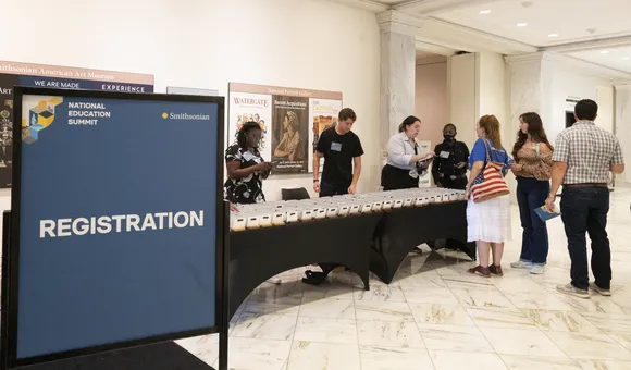 A sign says Registration and a group of people approach a table
