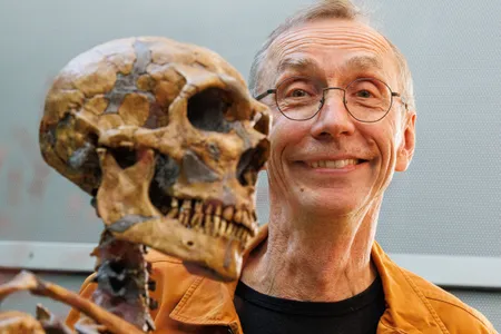 Svante P&auml;&auml;bo poses with a model of a Neanderthal skeleton after winning the 2022 Nobel Prize in Physiology or Medicine.

