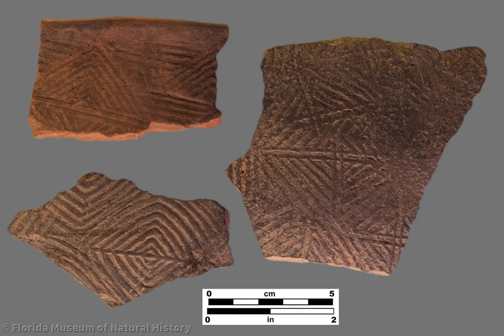 three pieces of pottery with patterns of squares and triangles pressed into them