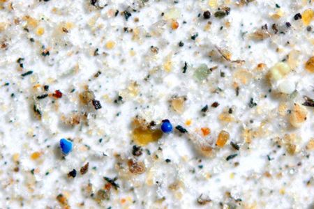 Blue pieces of microplastic viewed under a microscope alongside dust, minerals and charcoal collected from a park in Idaho. 