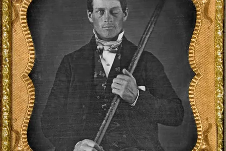 Photograph of cased-daguerreotype studio portrait of brain-injury survivor Phineas P. Gage (1823–1860) shown holding the tamping iron which injured him.