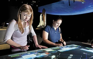 Visitors assemble space station elements in the Moving Beyond Earth gallery.