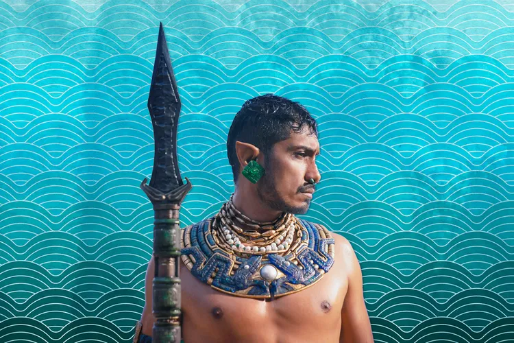 Illustration of Namor, king of Talokan, in front of a blue ocean-themed background