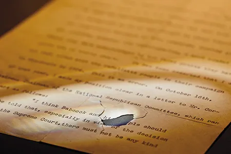 The first page of Theodore Roosevelt's speech that was damaged when a bullet tore through it.