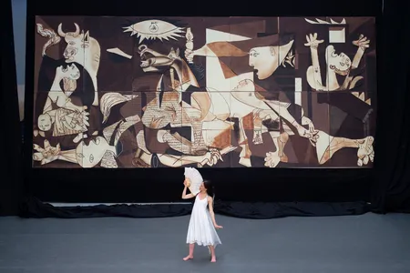A dancer performs during the public presentation of a life-size chocolate version of Picasso's Guernica.