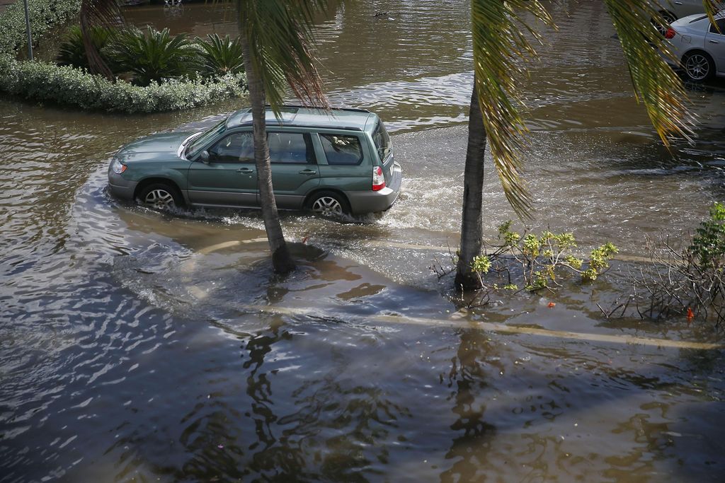A vehicle drives through flooded streets caused by the combination of the lunar orbit which caused seasonal high tides and what many believe is the rising sea levels due to climate change on September 30, 2015 in Fort Lauderdale, Florida