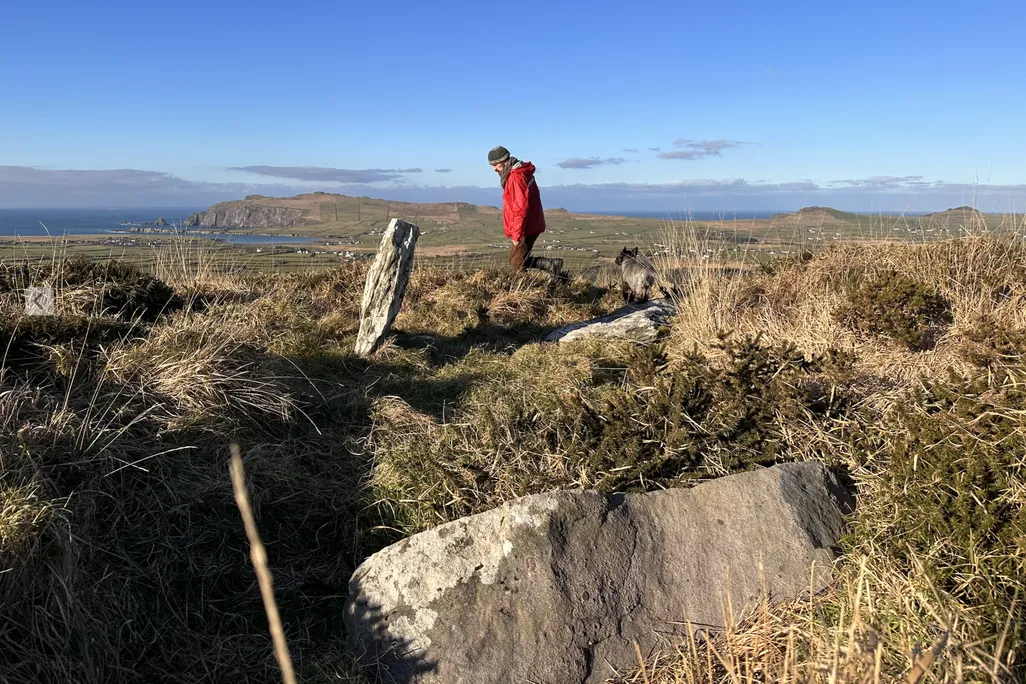 Man in a red jacket on a hilltop