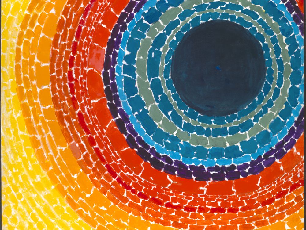 Painting with a dark blue center circle surrounded by concentric circles of reds, oranges, and yellow