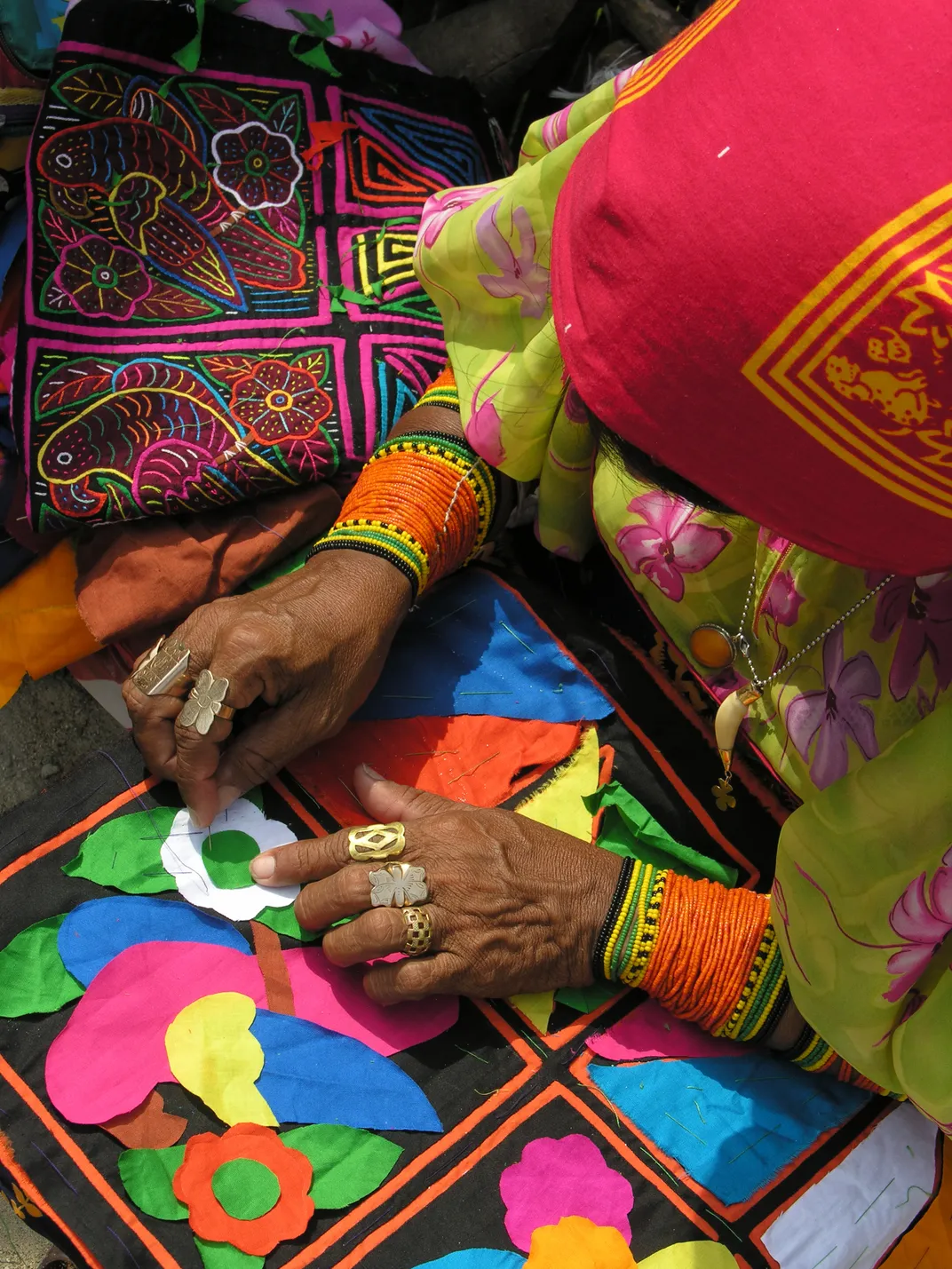 woman sewing a mola