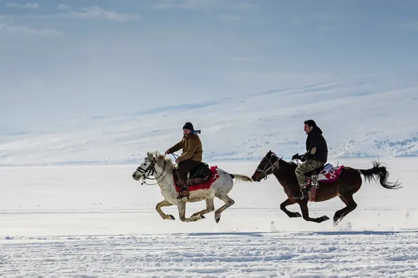 Villagers riding horses on the snow in the village. thumbnail