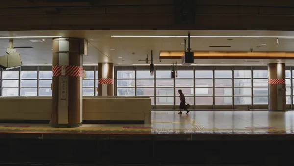 An elderly woman walking towards the stairs at a Tokyo-Station. thumbnail