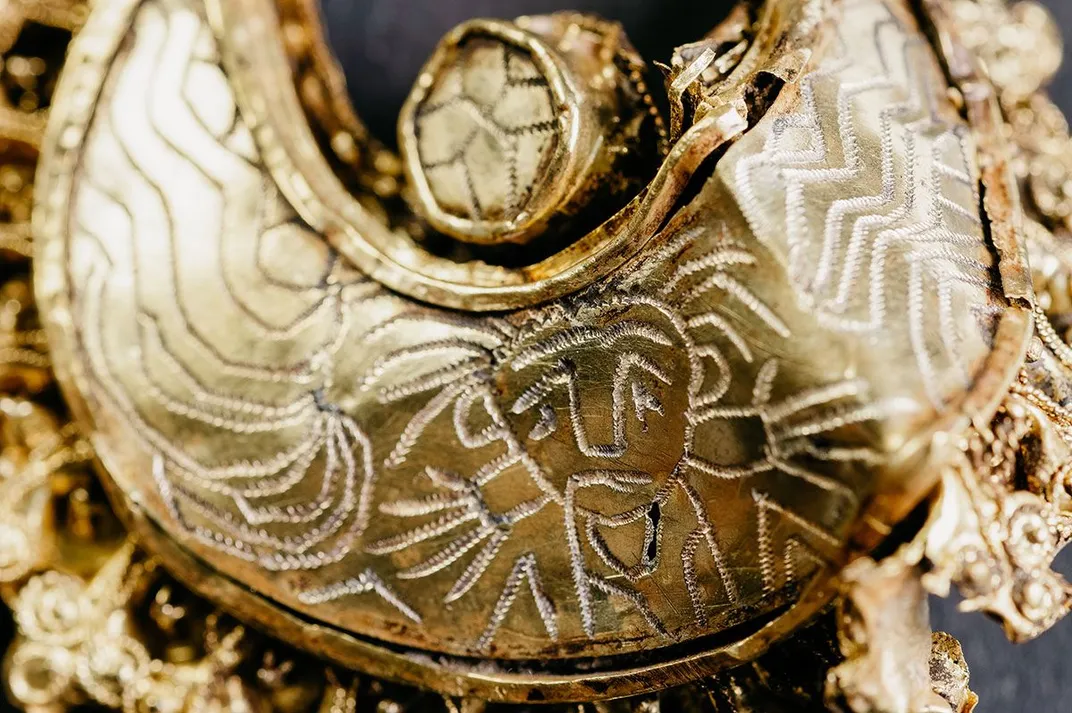 Close-up of gold earring with Christ portrait engraving