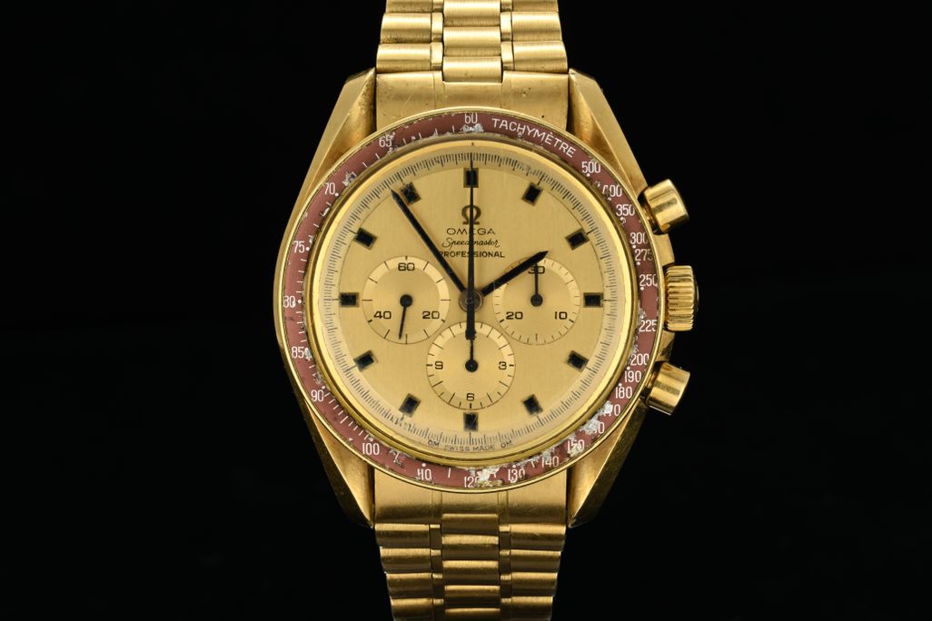 Gold watch against black background